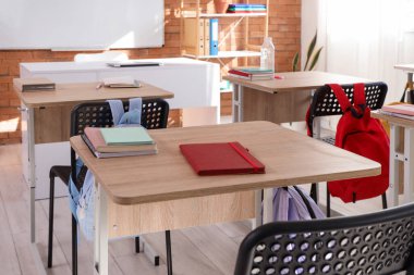 Boş sınıftaki defterler masanın üzerinde.