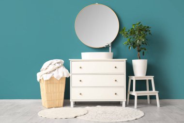 Çamaşır odasında kirli giysiler ve çekmecelerle dolu bir sepet.