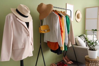 İçinde manken, elbise askılığı ve kanepe olan bir soyunma odası.