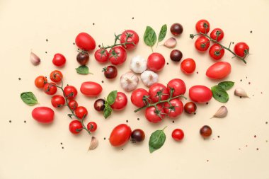 Bej arka planda sarımsak, fesleğen ve biberli taze olgun domatesler.