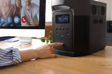 Genç bir kadın ofiste portatif güneş istasyonuna dönüşüyor.