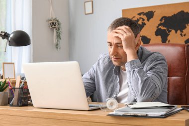 Masada dizüstü bilgisayarla çalışan yetişkin bir serbest çalışan.