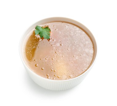 Beyaz arka planda bir kase lezzetli sebze suyu.