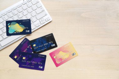 Bej ahşap arka planda kredi kartı olan klavye