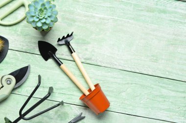 Yeşil ahşap arka planda bahçe aletleri seti