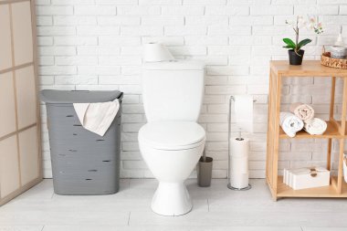 Çamaşır sepetli, hafif tuvaletin şık bir iç mekanı.