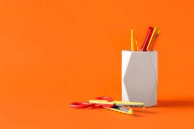 Renk arkaplanında kalem ve makas tutan