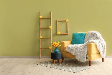 Oturma odasında ekose, merdiven ve nergis çiçekli rahat bir koltuk.