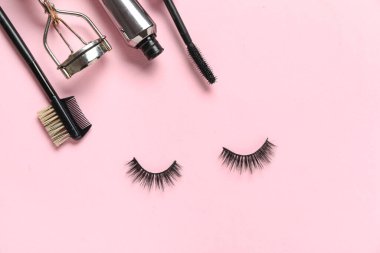 Makyaj aksesuarları, rimel ve pembe arka planda takma kirpikler.