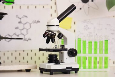 Modern mikroskop ve kimyasal mataralar genç kızların odasındaki ruh hali tahtasına karşı.