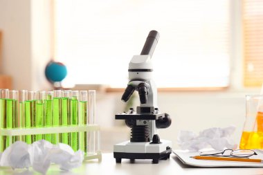 Modern mikroskop, kimyasal mataralar, not defteri ve gözlükler...