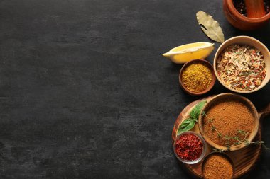 Koyu arkaplanda taze aromatik baharatlar içeren kompozisyon