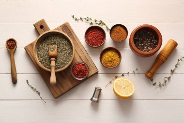 Beyaz ahşap arka planda farklı aromatik baharatlar içeren kompozisyon