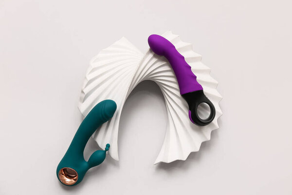 Clitoral vibrators and plaster decor on grey background