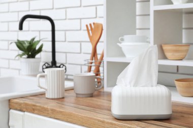 Kağıt mendil ve mutfak gereçleri olan bir tutucu.