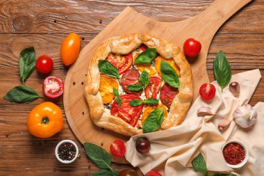 Lezzetli domates galeti, fesleğen ve baharatlı ahşap arka planda kompozisyon