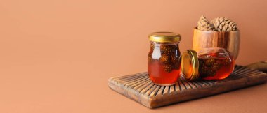 Bej arkaplanda lezzetli kozalak reçeli kavanozları ve metin için boşluk