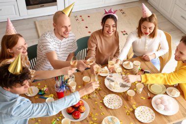 Şampanyalı bir grup genç arkadaş mutfakta doğum gününü kutluyorlar.