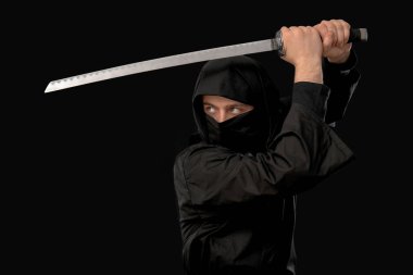 Siyah arka planda kılıç taşıyan erkek ninja.
