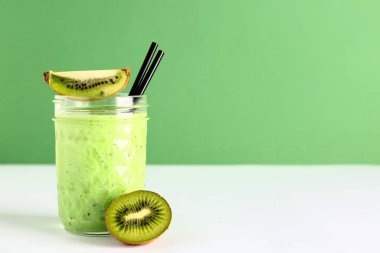 Beyaz masada bir bardak taze kivi püresi.