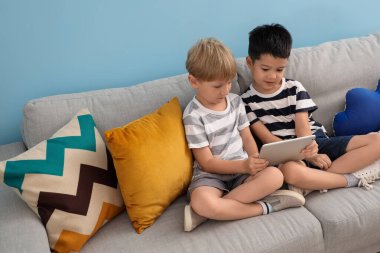 Evde tablet bilgisayarla oynayan sevimli çocuklar.