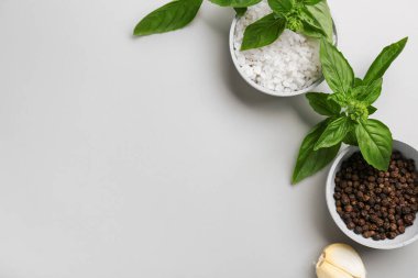 Gri arka planda deniz tuzu, biber ve fesleğen kaseleri