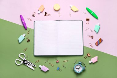 Renkli arkaplanda farklı kırtasiye malzemesi olan defter