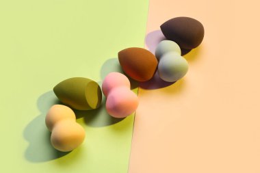 Renkli arkaplanda farklı makyaj süngerleri