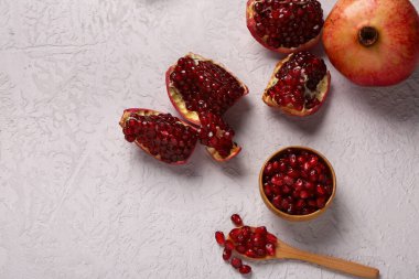 Taze nar ve beyaz zemin üzerinde tohumlar olan kase.