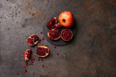 Taze nar ve koyu arkaplanda bir kase tohum.