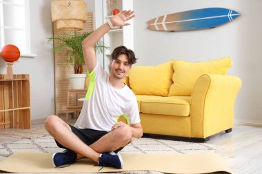 Sportif genç adam evde geriniyor.