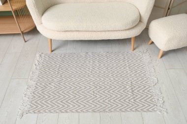 Şık halısı, beyaz kanepesi ve puf olan oturma odasının içinde.