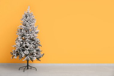 Turuncu duvarın yanında güzel bir Noel ağacı