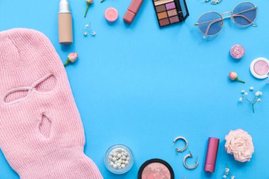 Çerçeve kar maskesi, kadın aksesuarları ve renk arka planında kozmetik ürünler