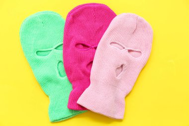 Set of stylish balaclavas on yellow background clipart