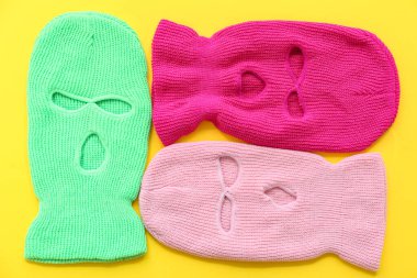 Set of stylish balaclavas on yellow background clipart