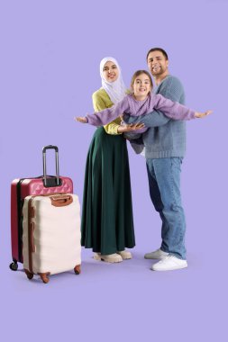 Leylak arkaplanlı bavulları olan güzel Müslüman bir aile. Seyahat kavramı