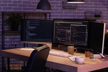 Geceleri bilgisayar monitörlü programcının işyeri