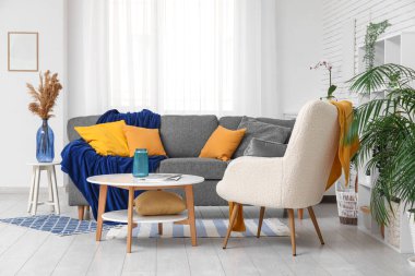 Yumuşak kanepesi, koltuğu ve sehpası olan bir oturma odası.