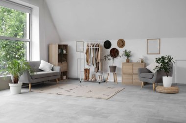 Elbise askısı, klozet ve kanepesi olan soyunma odasının içinde.