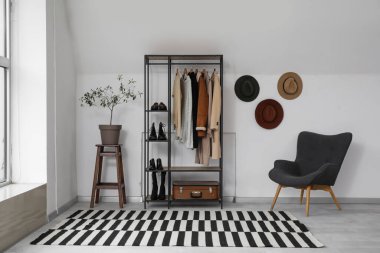 Elbise askısı, şapkası ve koltuğu olan soyunma odasının içinde.