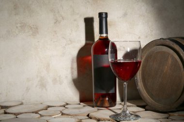 Fıçı, şişe ve kırmızı şarap ahşap masada grunge bej arka planda