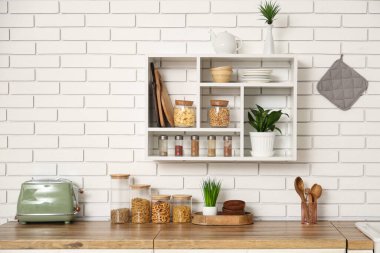 Raflarda ve mutfak tezgahlarında farklı ürünler olan cam kavanozlar.