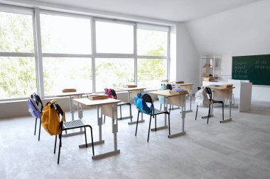 Sıraları, sandalyeleri ve tahtası olan boş sınıfın içi.