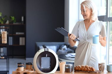 Ofiste kahve içen olgun bir kadın.