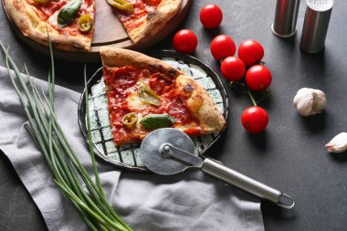 Lezzetli pizzalı kompozisyon ve koyu arkaplanda kesici.