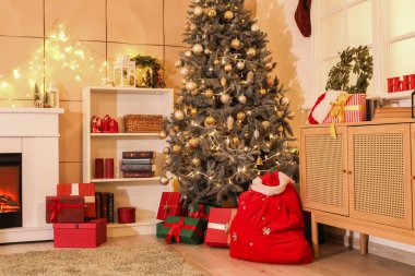 Noel Baba çantasıyla, hediye kutularıyla ve Noel ağacı süslenmiş rahat oturma odasının içinde.