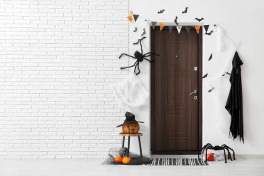 Cadılar Bayramı için salon kapısı, balkabağı ve örümceklerle süslenmiş.