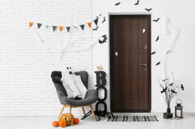 Cadılar Bayramı için salon kapısı, koltuğu ve hayaleti ile süslenmiş.