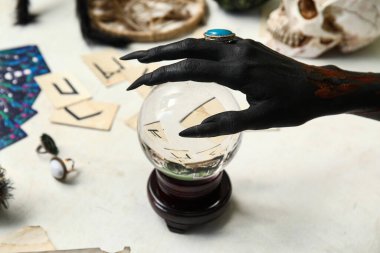 Kahrolası siyah cadı eli, kristal küre ve beyaz arka planda sihirli özellikler. Cadılar Bayramı